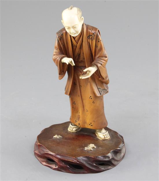 A Japanese ivory and boxwood okimono of a man, early 20th century, 17cm, losses